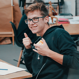 Aluno sorrindo na aula de Desenho e Ilustracao da Escola Casa